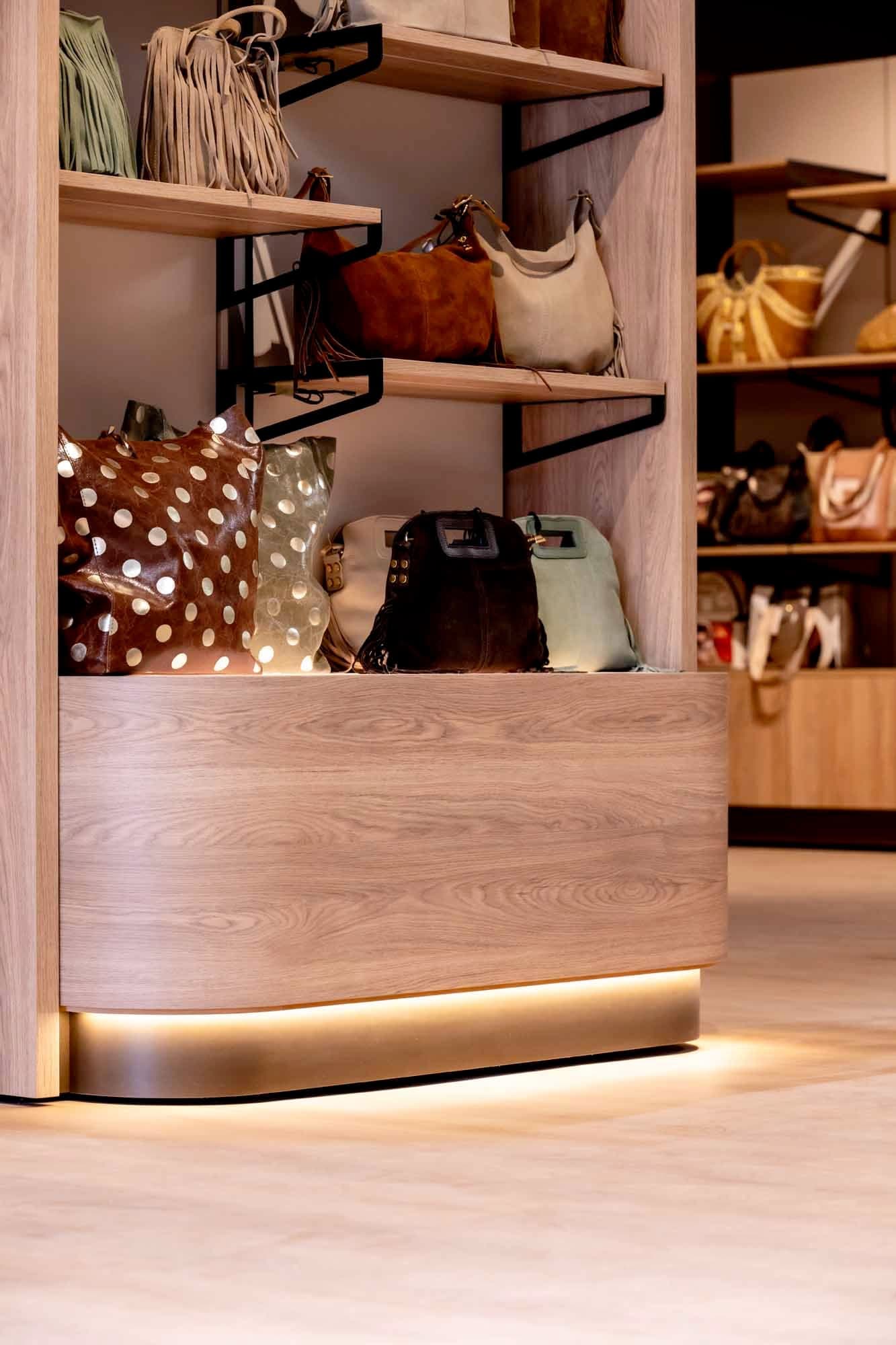 Curved podium lit from below, leather goods boutique